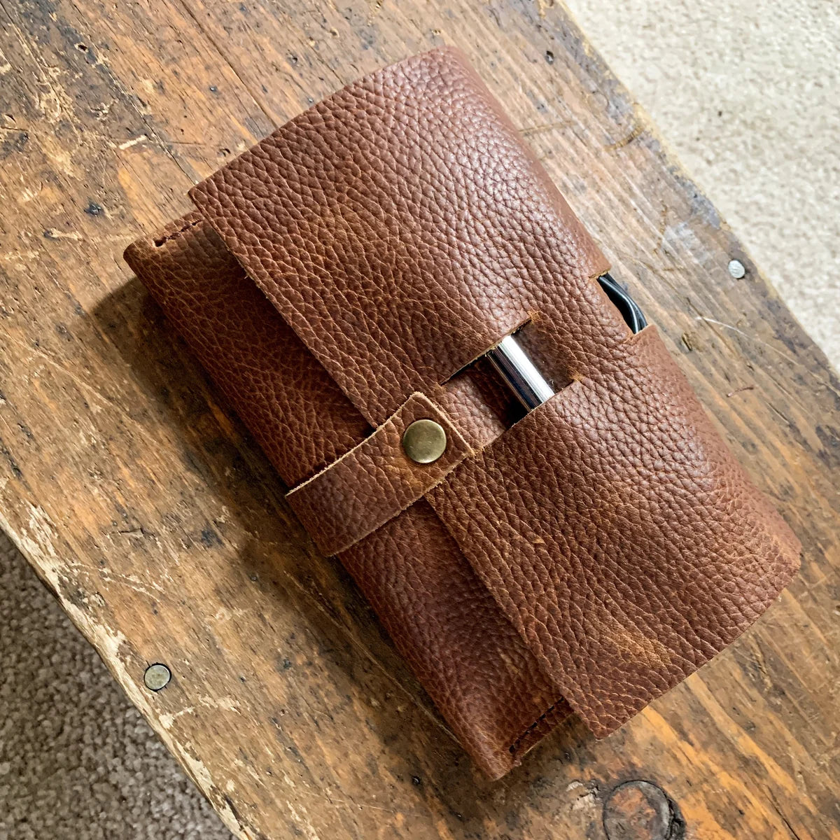 Brown top-grain leather Rogue Tech Organizer opened to show its cable holders and interior phone pocket.